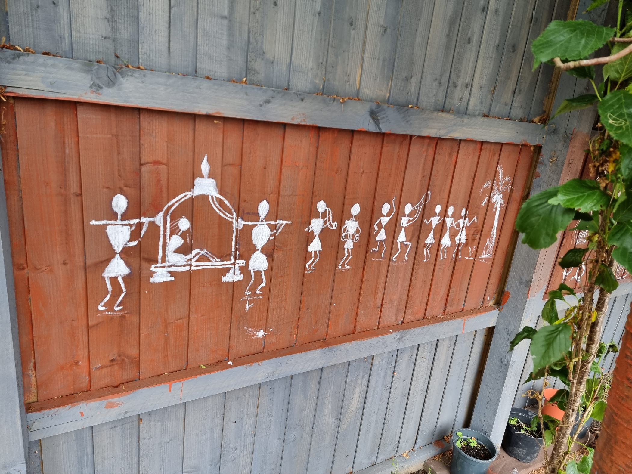 Painting on fence of white stick people