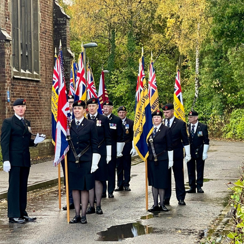 Members of the Armed Forces stand with flags