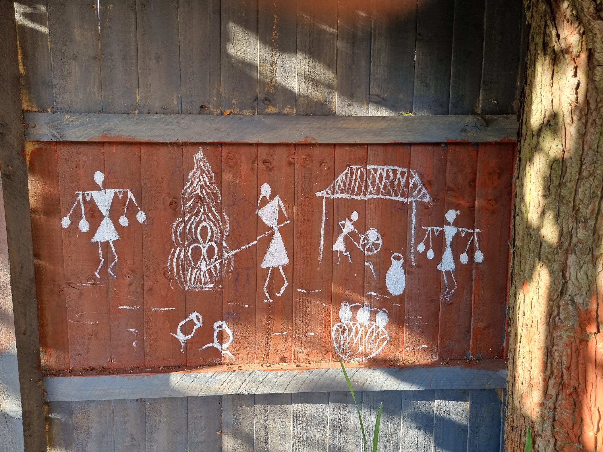 Painting on fence of white stick figures