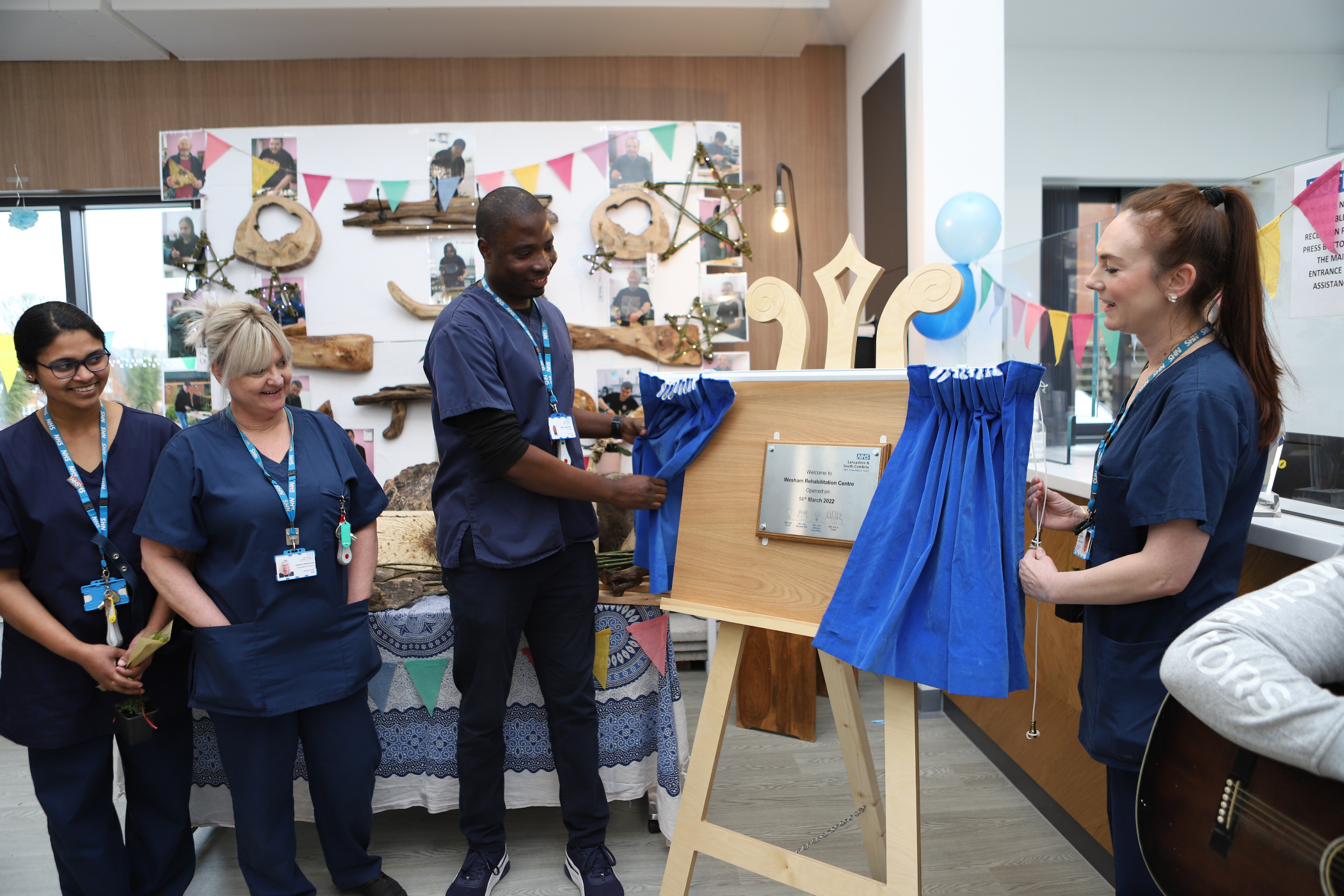 Staff members at Wesham Rehab with plaque