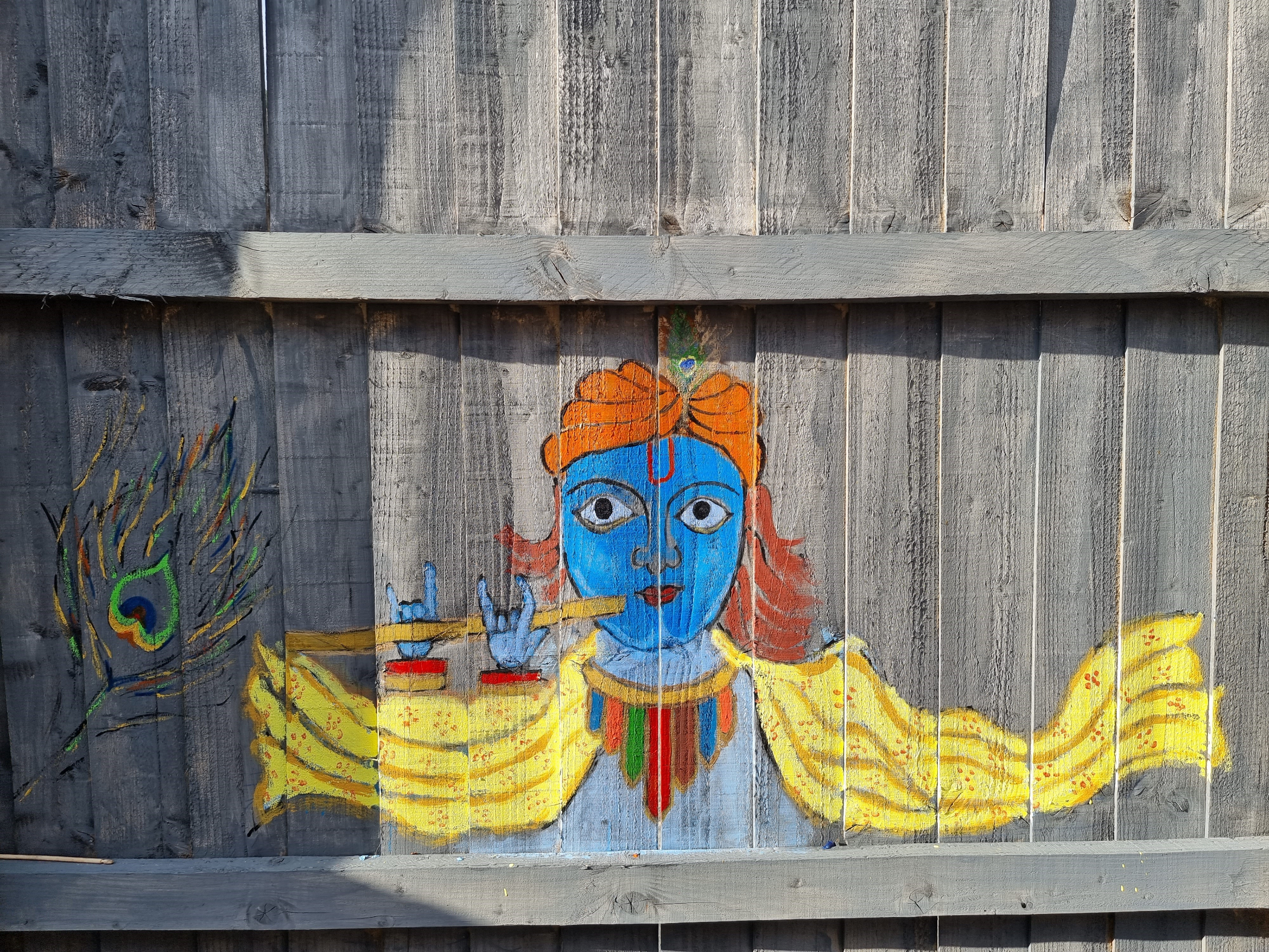 Painting on fence of Krishna playing the Flute