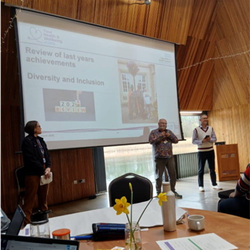 People stand in front of projected screen at event. 