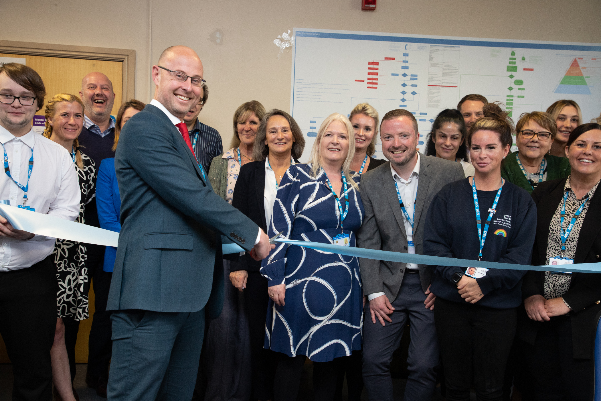 Chris Oliver cutting blue ribbon with Initial Response Service staff .jpg