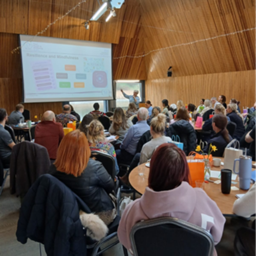 People sit round tables at an event. 