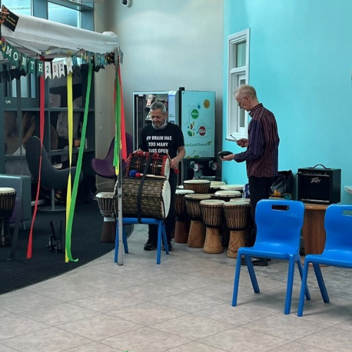 Person playing West African drum.