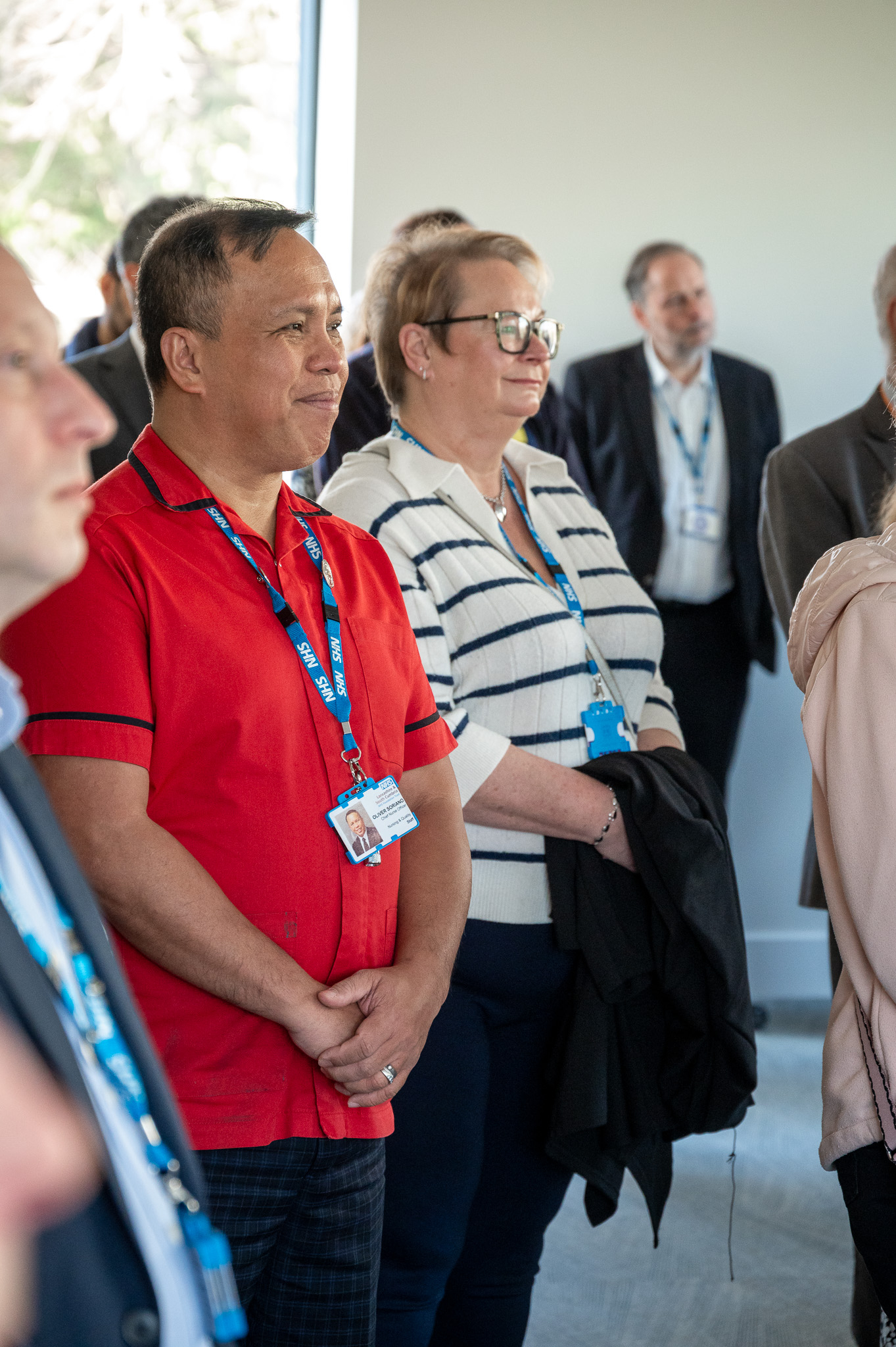 a man wearing red nurse uniform watching a presentation 