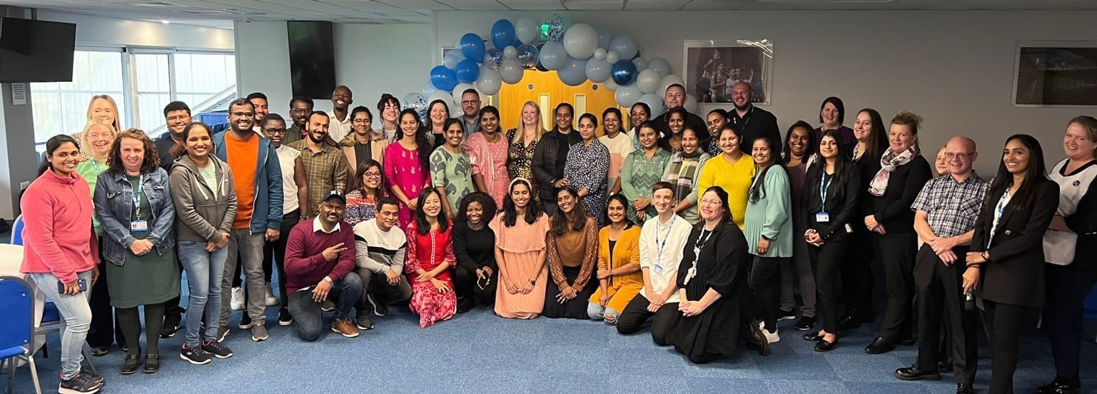 group of international nurses in front of balloon arch